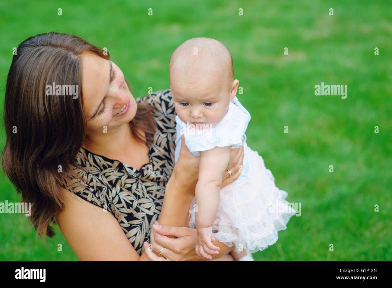 Madre giovane figlia di contenimento nelle sue braccia Foto Stock