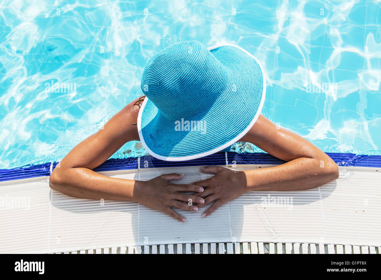 La donna nel cappello per il sole in piscina. Vista dall'alto. Foto Stock