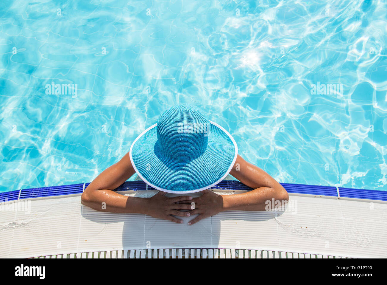 La donna nel cappello per il sole in piscina. Vista dall'alto. Foto Stock