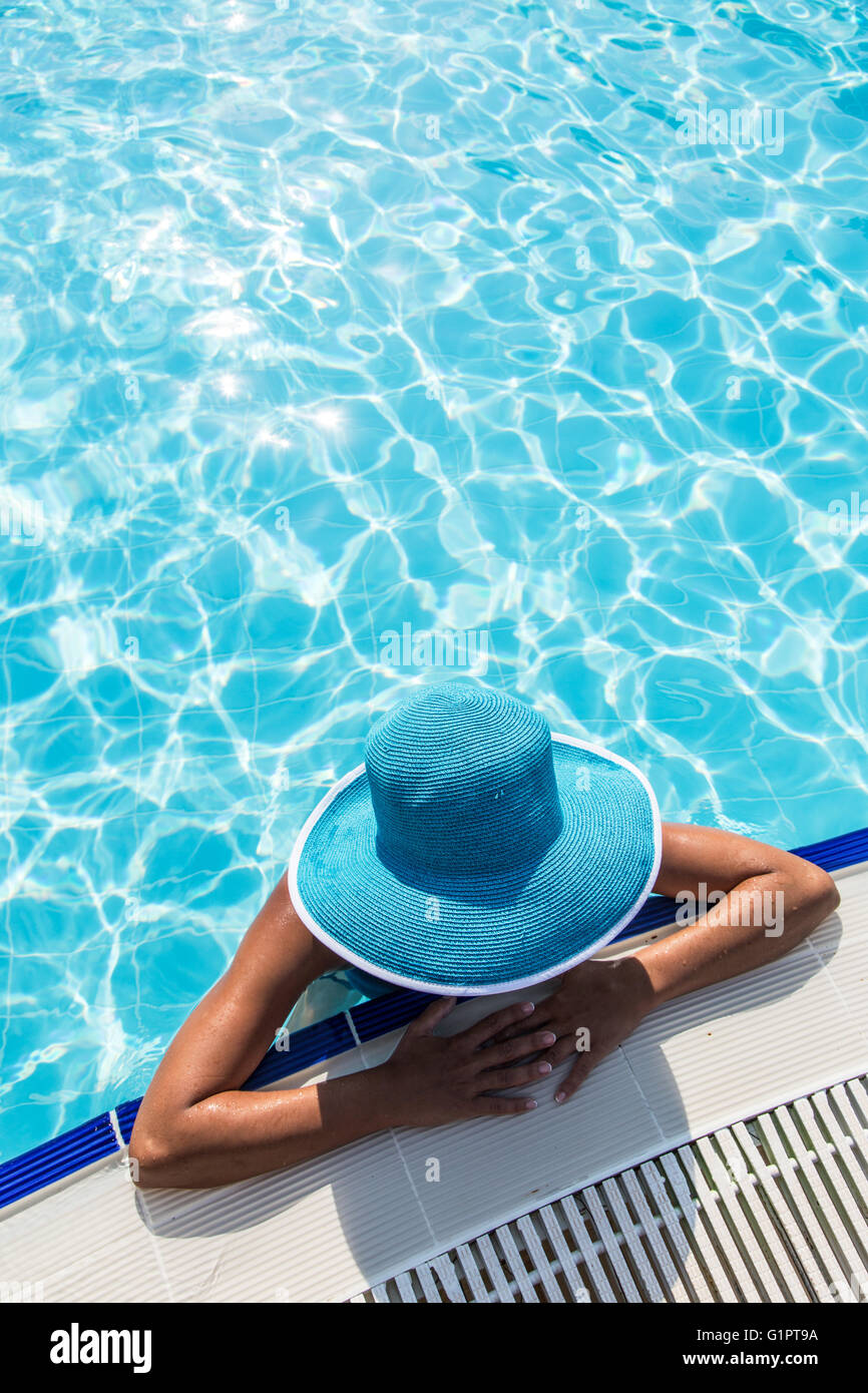 La donna nel cappello per il sole in piscina. Vista dall'alto. Foto Stock