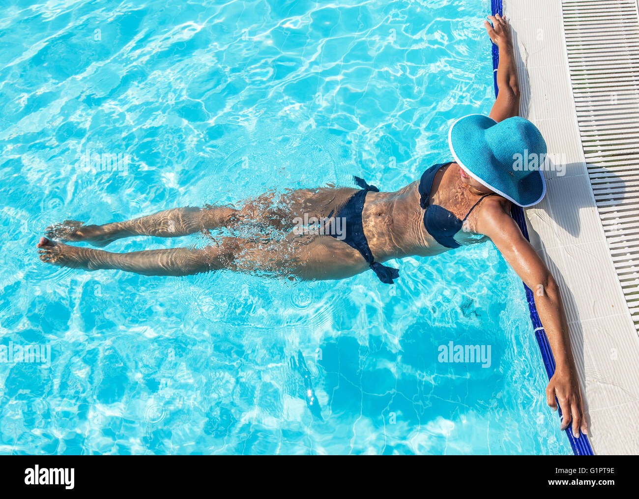 La donna nel cappello per il sole in piscina. Vista dall'alto. Foto Stock