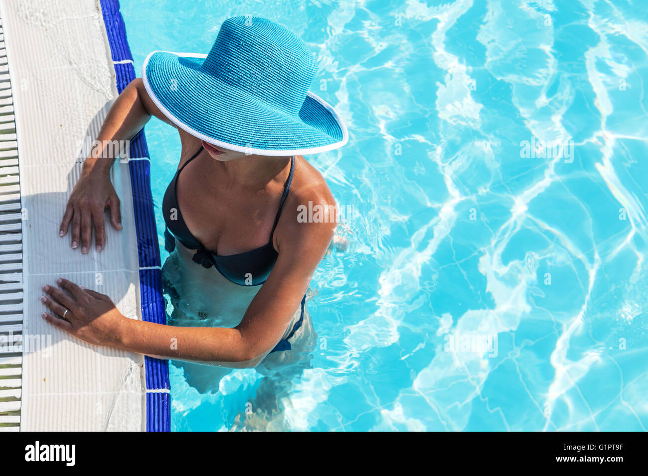 La donna nel cappello per il sole in piscina. Vista dall'alto. Foto Stock