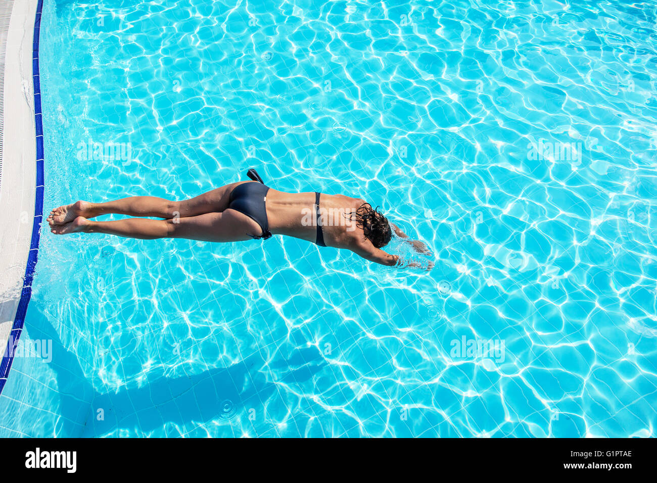 Donna che si tuffa in piscina. Foto Stock