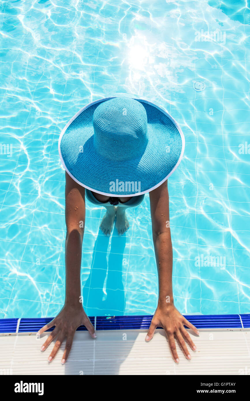 La donna nel cappello per il sole in piscina. Vista dall'alto. Foto Stock