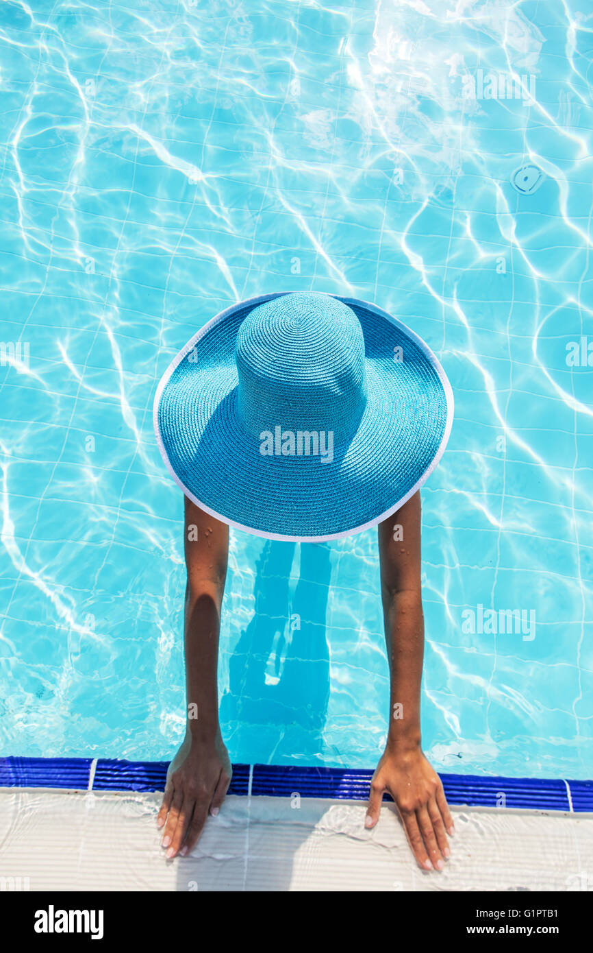 La donna nel cappello per il sole in piscina. Vista dall'alto. Foto Stock