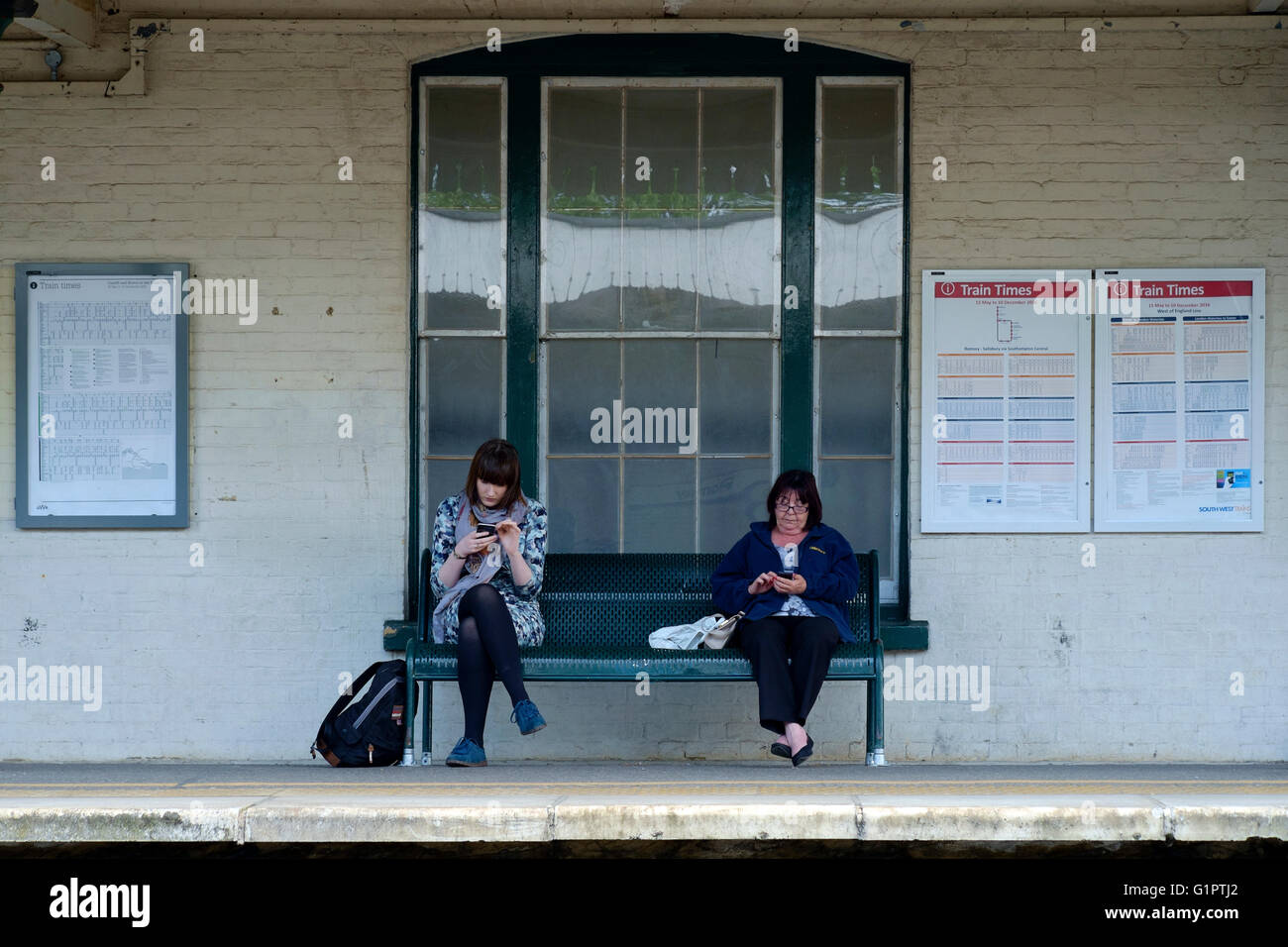 Rampa femmina i passeggeri seduti in attesa del treno regno unito Foto Stock