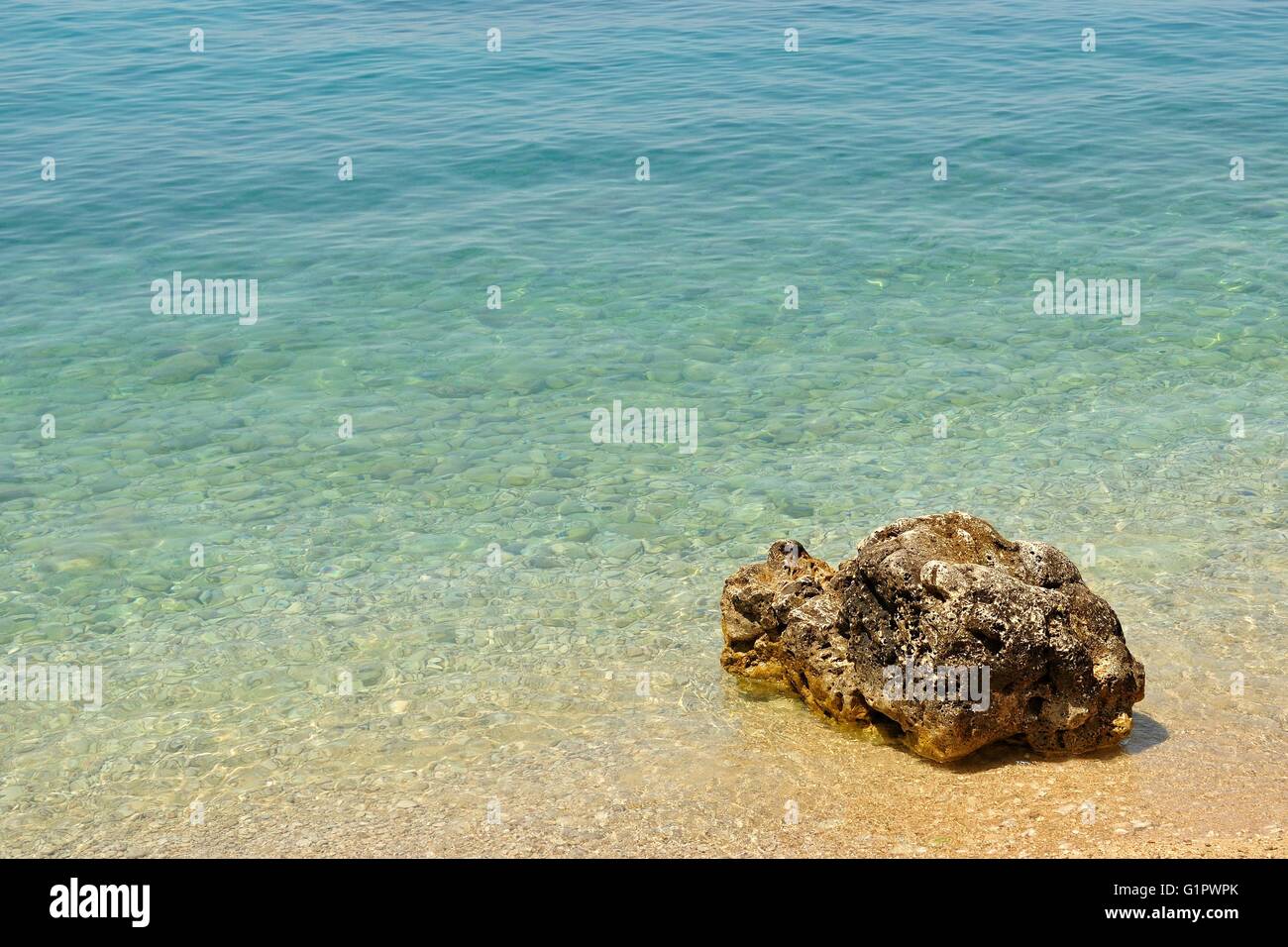 Bellissima spiaggia con grande pietra come sfondo in Podgora, Croazia. Spazio nel lato superiore Foto Stock