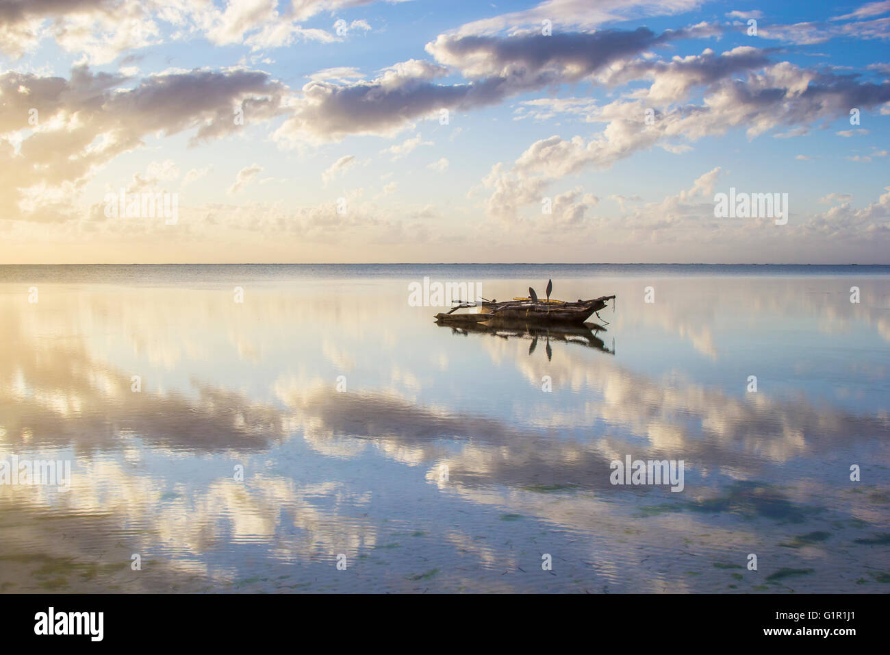 Paesaggi acquatici pacifica con un tradizionale vecchio peschereccio chiamato dhow riflessa sulla superficie. Tanzania, Zanzibar Foto Stock