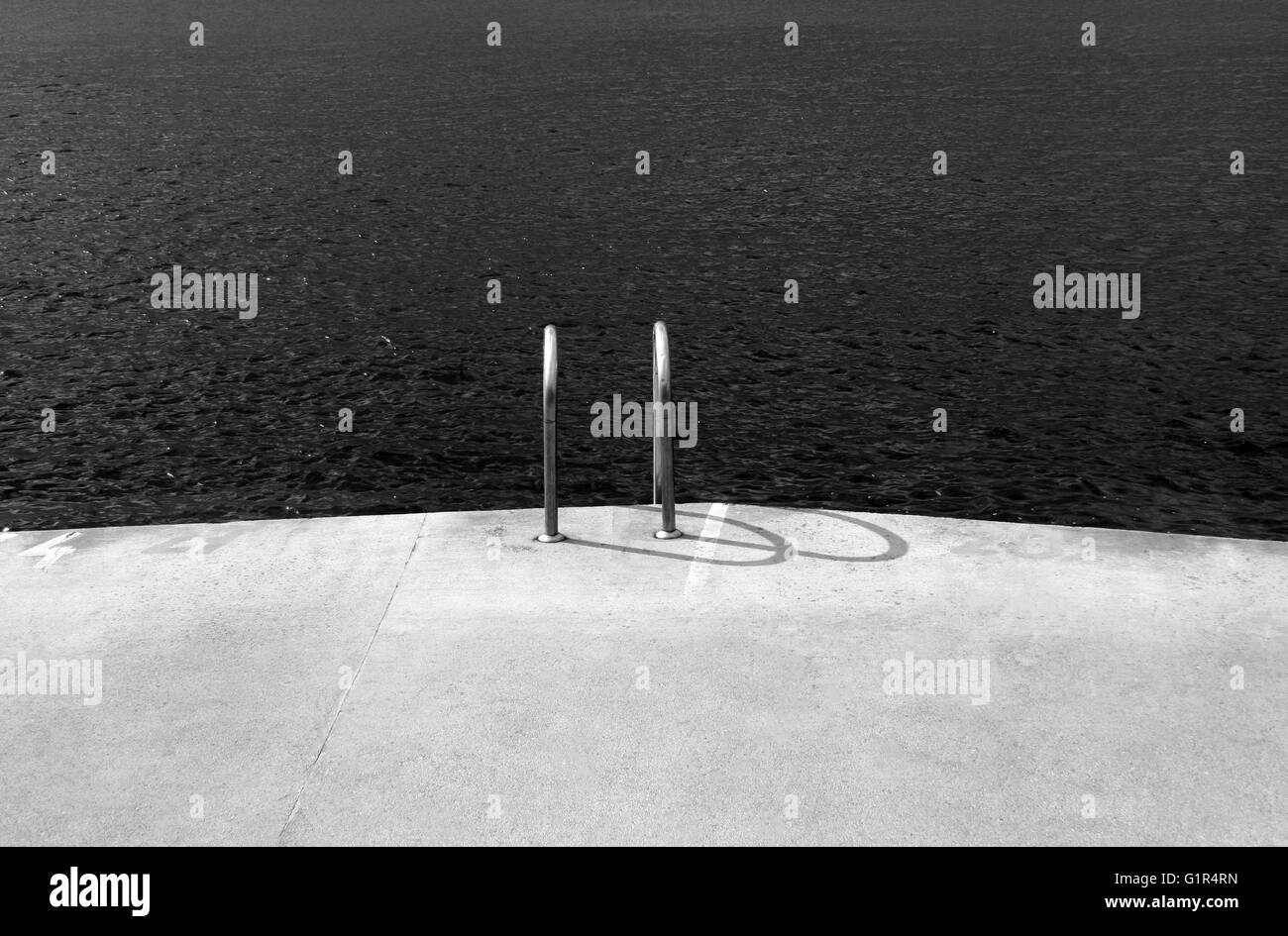 Vista orizzontale di un ponte concreto accanto all'Oceano con piscina chrome scale con n. di persone intorno a Foto Stock