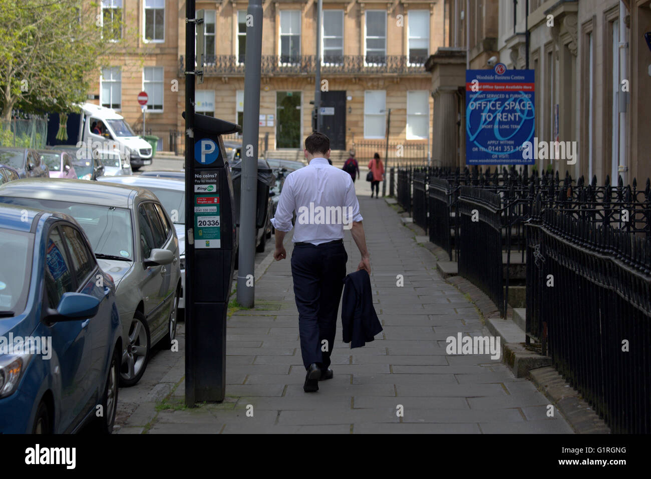 Giovane maschio lavoratore di ufficio dopo il lavoro con la camicia fuori su una calda giornata sulla città strada georgiana con segni Glasgow, Scotland, Regno Unito. Foto Stock