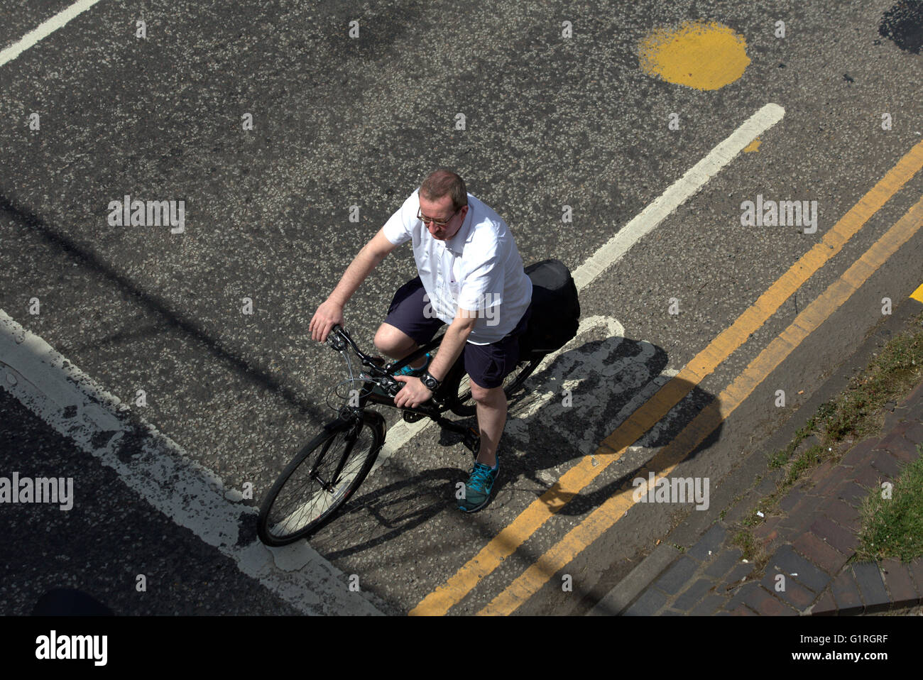 Uomo di mezza età ciclista bike in attesa in un angolo della città di traffico in attesa di luce visto dal di sopra, Glasgow, Scotland, Regno Unito Foto Stock