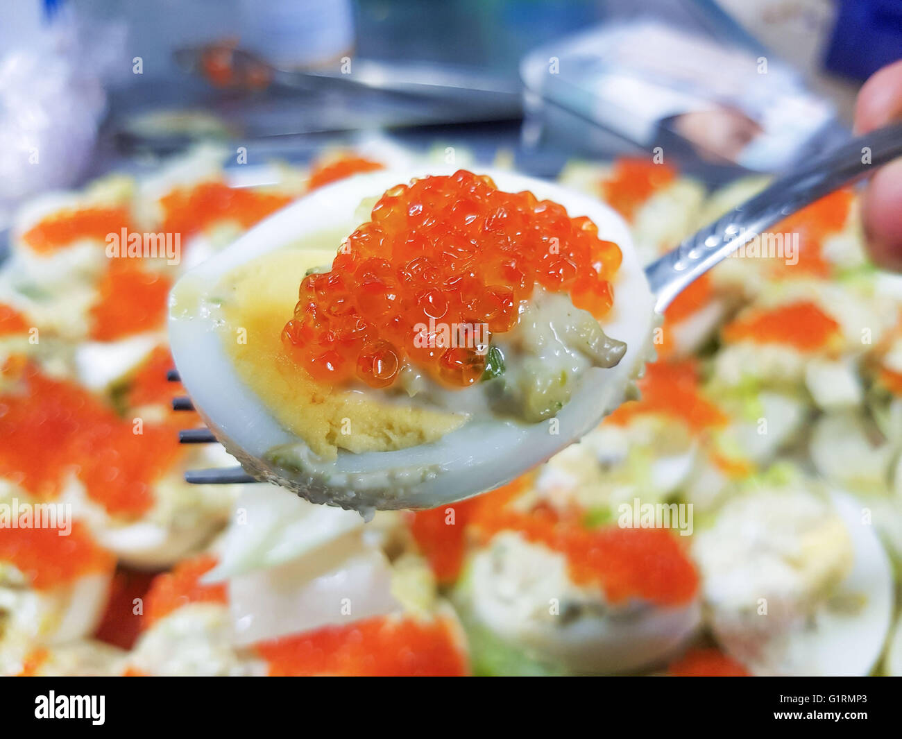 Uovo su un cucchiaio e rabboccato con salmone roe, sopra più uova roe Foto Stock