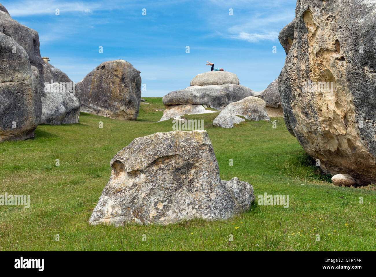 Giovane donna in posa sul Elephant Rocks su North Otago, Nuova Zelanda Foto Stock