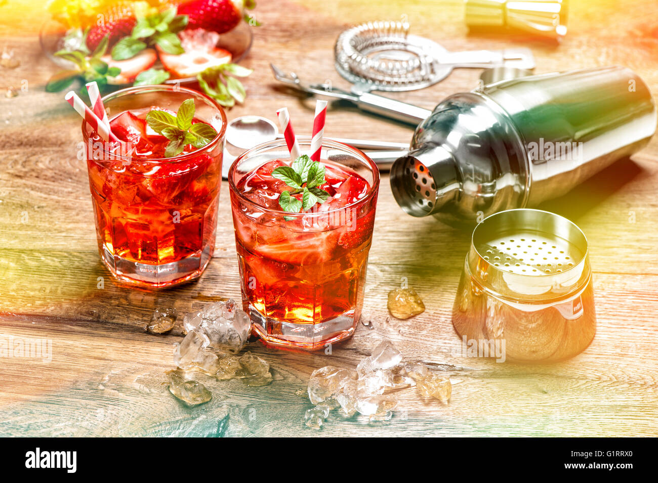 Red drink con ghiaccio. Bevande Bevande non alcoliche. Cocktail bar rendendo gli strumenti, fragola e menta. In stile vintage tonica pictur Foto Stock