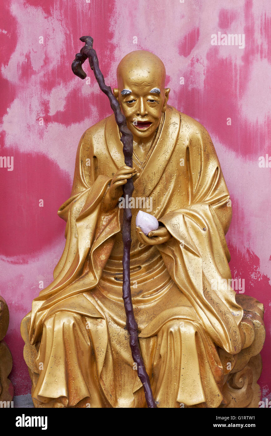 Arhat, buddista Salvia, come un uomo vecchio con un bastone, dorato della figura, Tempio di Diecimila Buddha, Sha Tin, Nuovi Territori di Hong Kong Foto Stock