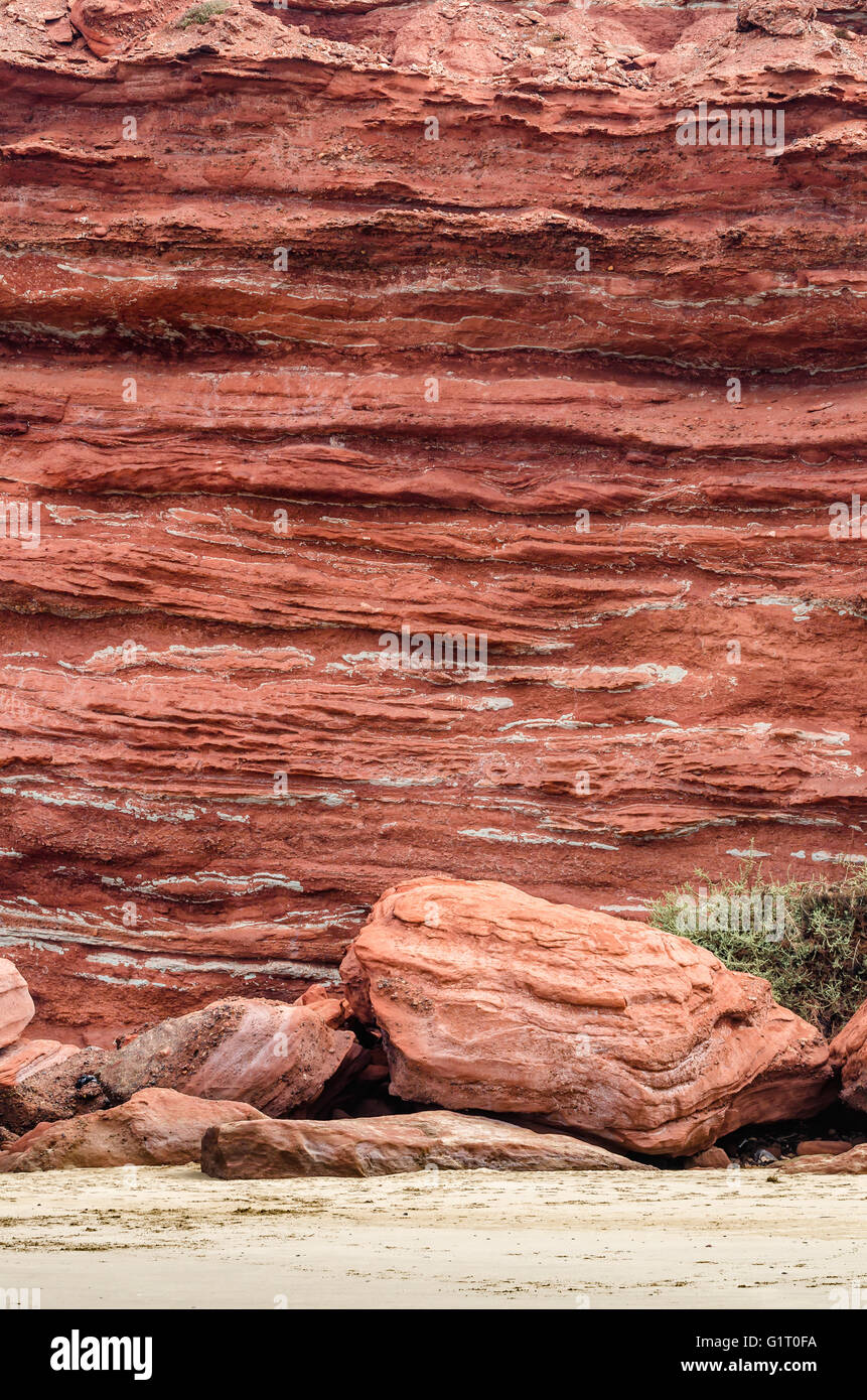 Parete rossa delle rocce sulla bellissima spiaggia sfondo Foto Stock