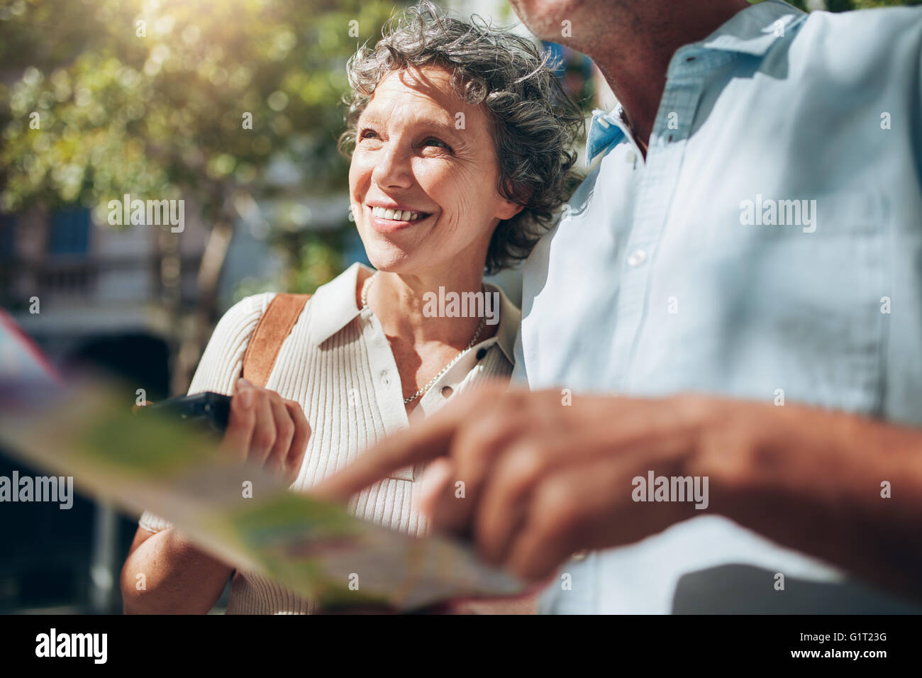 Senior donna con un uomo in possesso di una mappa della città. Felice e gioiosa, godendo in pensione. Foto Stock
