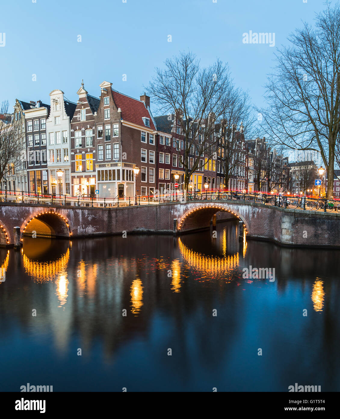 Una vista dei ponti a Leidsegracht e Keizersgracht intersezione dei canali di Amsterdam al crepuscolo. Percorsi da traffico può essere Foto Stock
