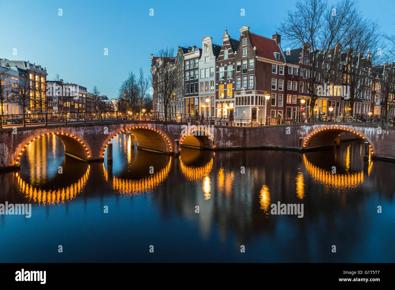Una vista dei ponti a Leidsegracht e Keizersgracht intersezione dei canali di Amsterdam al crepuscolo. Foto Stock
