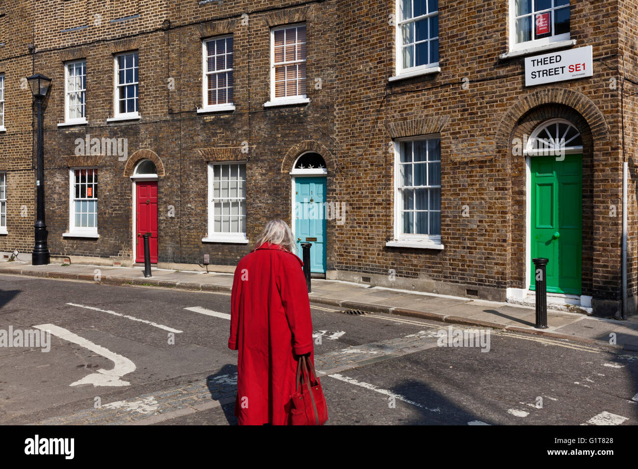 Una signora anziana guarda giù Theed Street a Lambeth, Londra, Inghilterra. Foto Stock