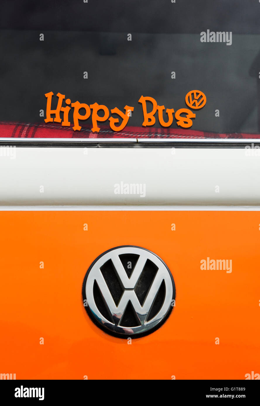 Orange VW Volkswagen camper van estremità posteriore con un bus hippy etichetta nella finestra Foto Stock