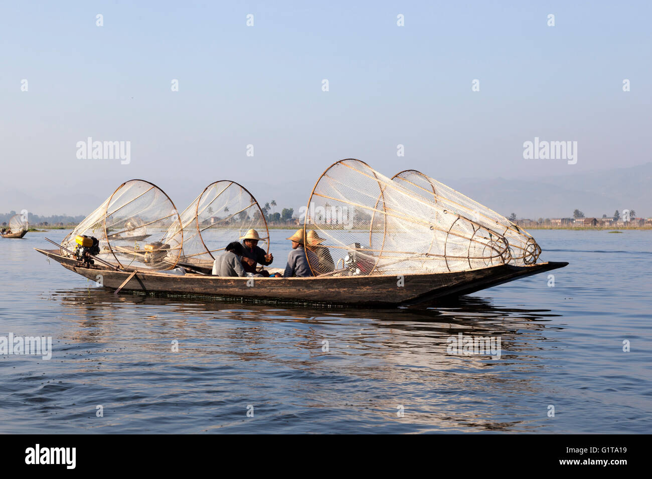 Sul Lago Inle, motorizzato due piroghe ancorate a fianco a fianco con i pescatori in appoggio un po' (Myanmar). Foto Stock