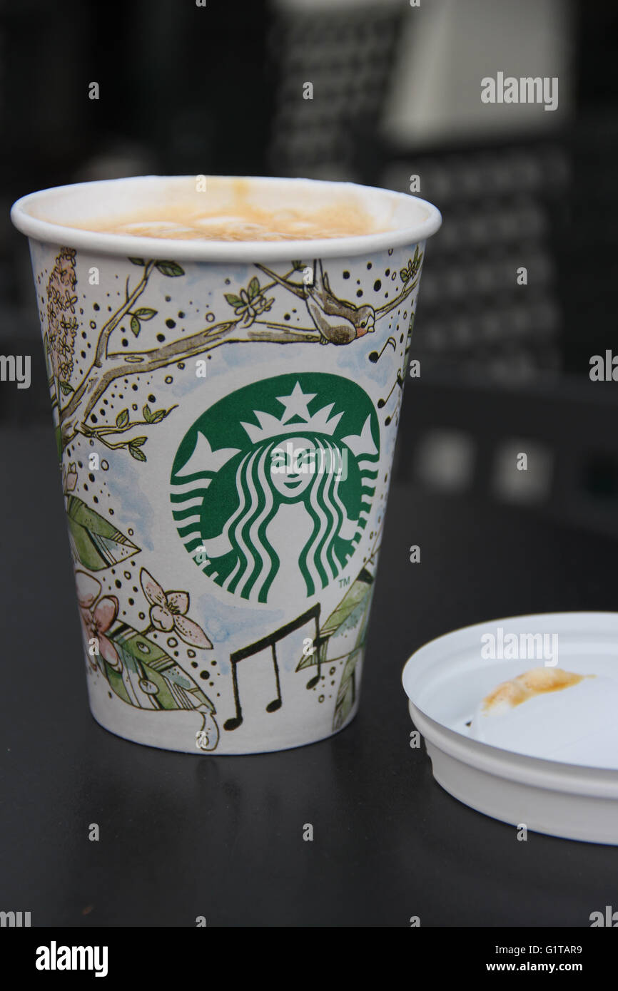 Un caramello macchiato da Starbucks servita in un bicchiere di carta Foto Stock