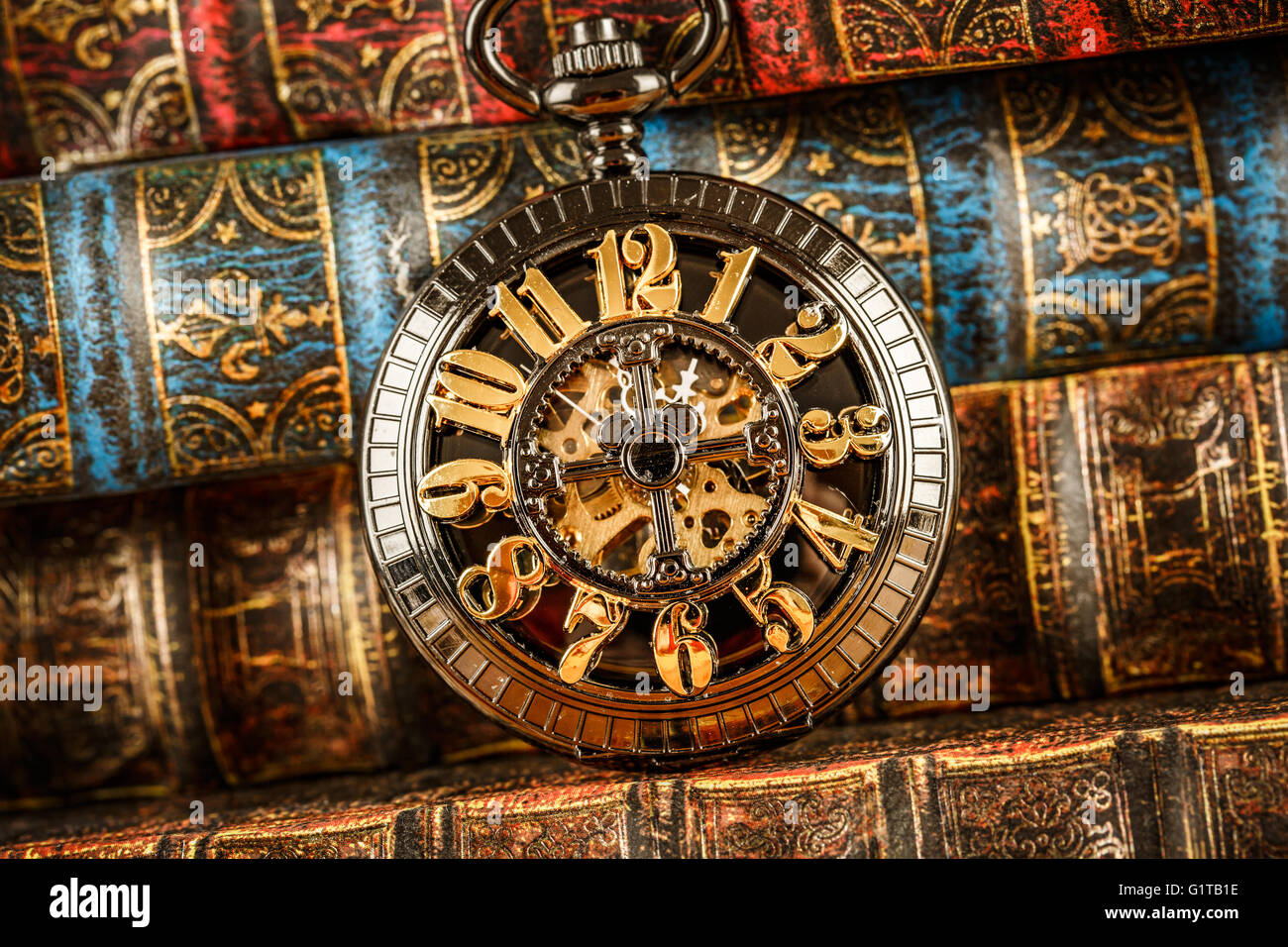 Vintage antico orologio da tasca sullo sfondo di libri antichi Foto Stock
