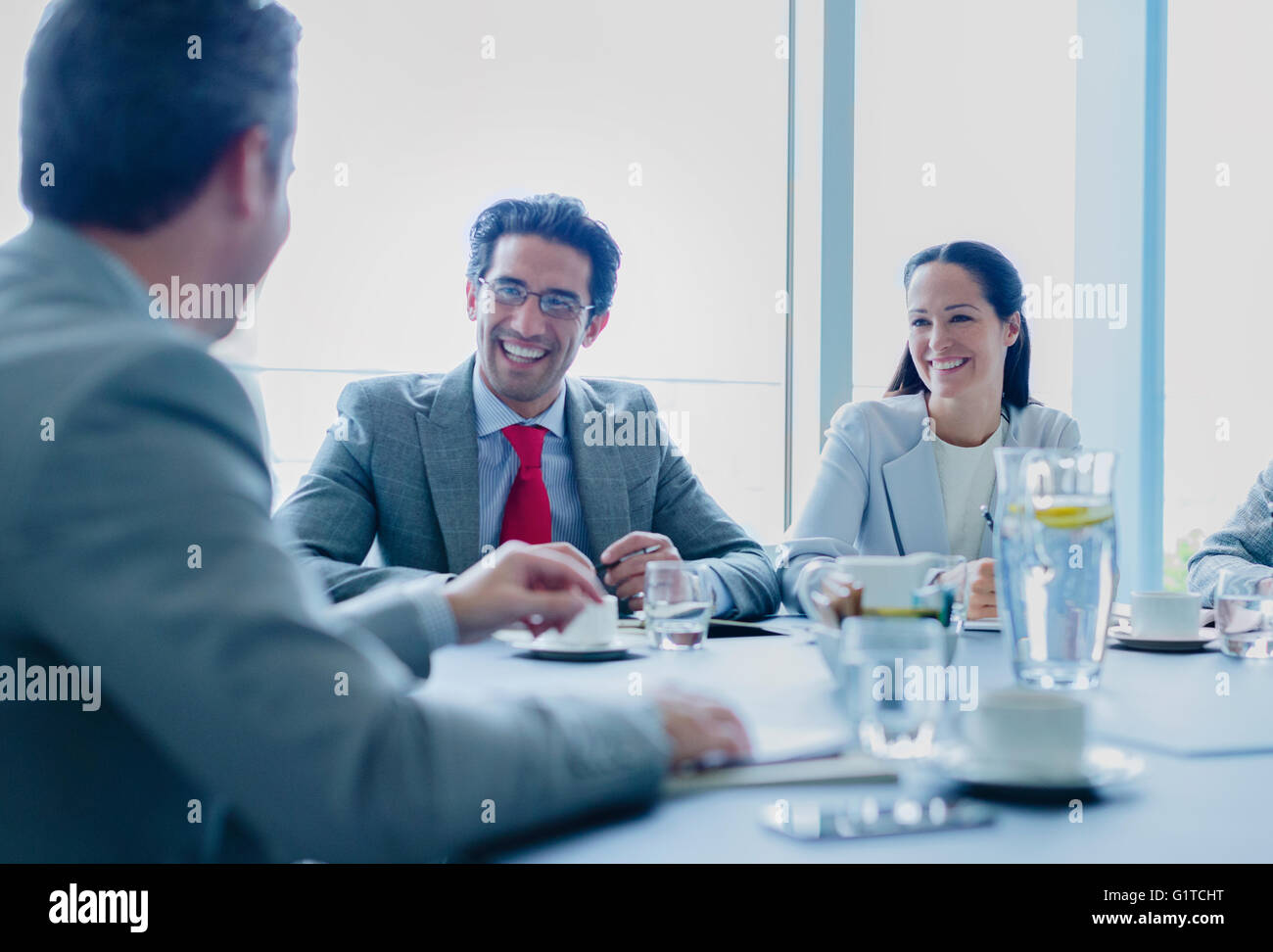 Sorridente business persone che parlano in sala conferenze Foto Stock