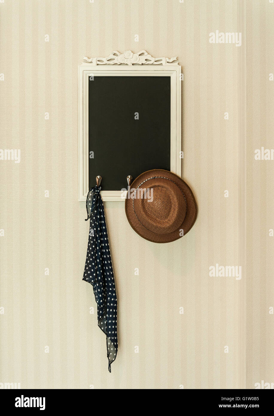 Ardesia Vintage chalk board con fazzoletto e marrone cappello sulla parete Foto Stock