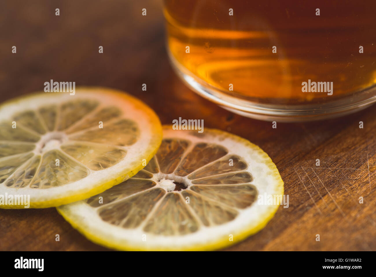 Vista prospettica del tè nero con limone in coppa e su tavola in legno tabella Foto Stock