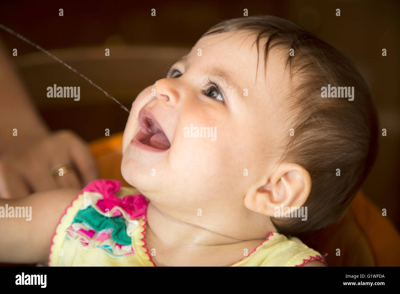 Close-up di un anno di età kid acqua potabile mentre guardando in alto Foto Stock