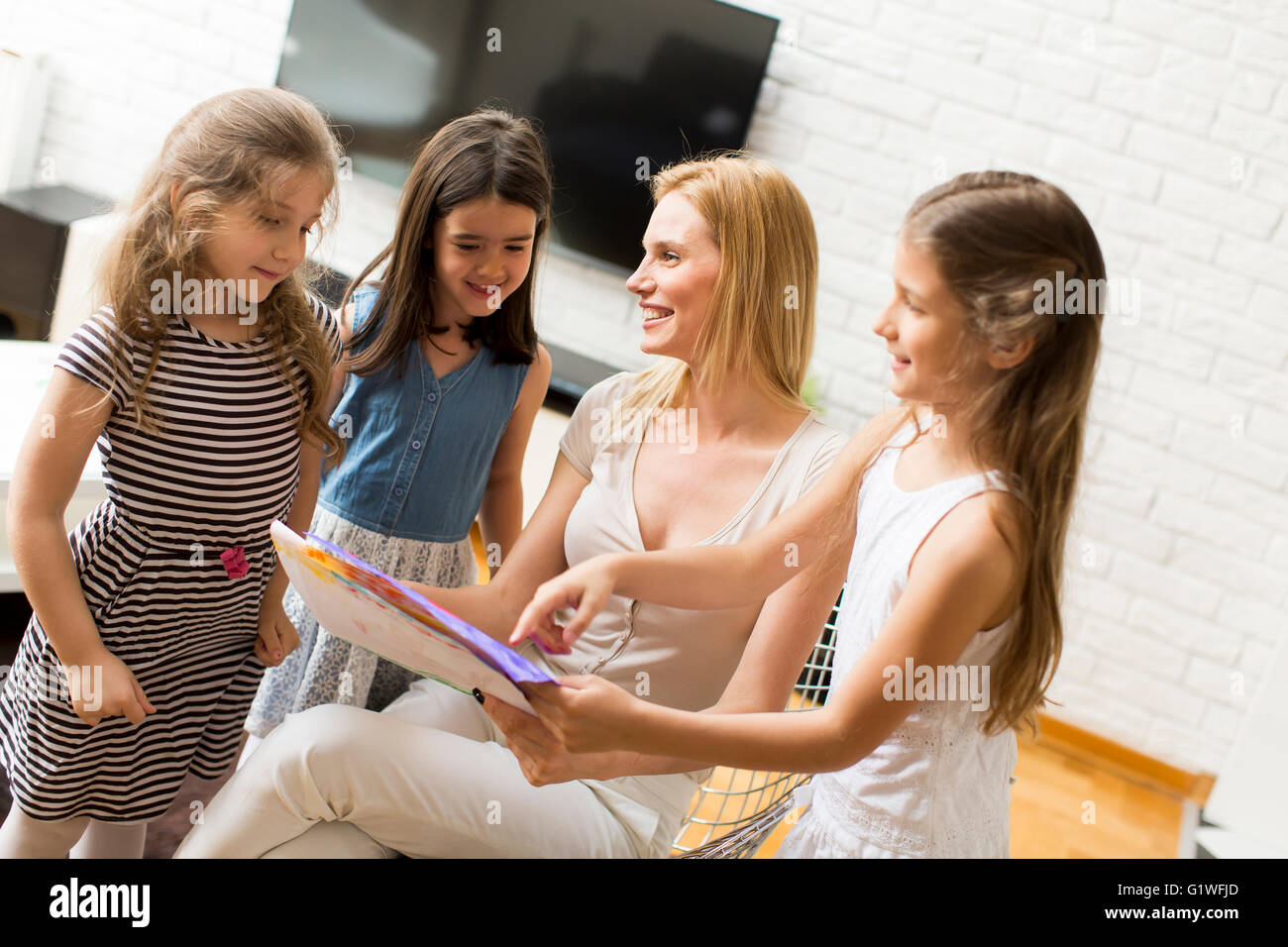 Ragazza che mostra un disegno per la madre a casa Foto Stock