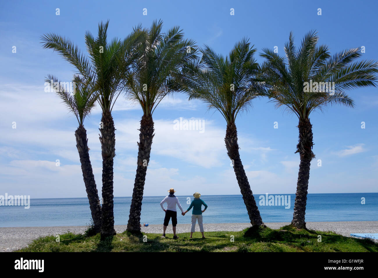 Palme e un paio su Herradura beach in Spagna Europa Foto Stock