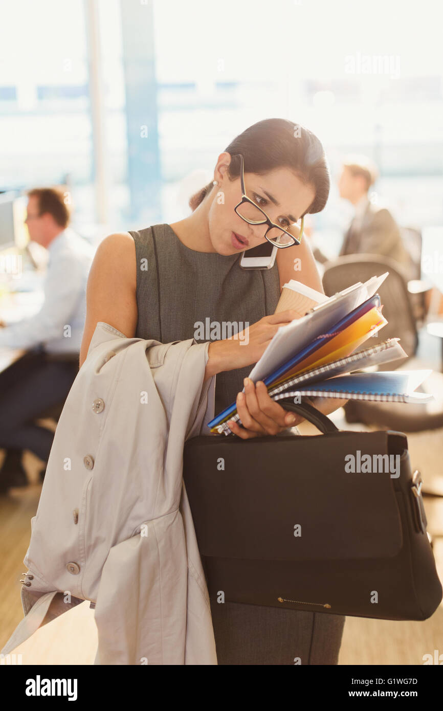 Sottolineato imprenditrice lottando per un multitasking in office Foto Stock