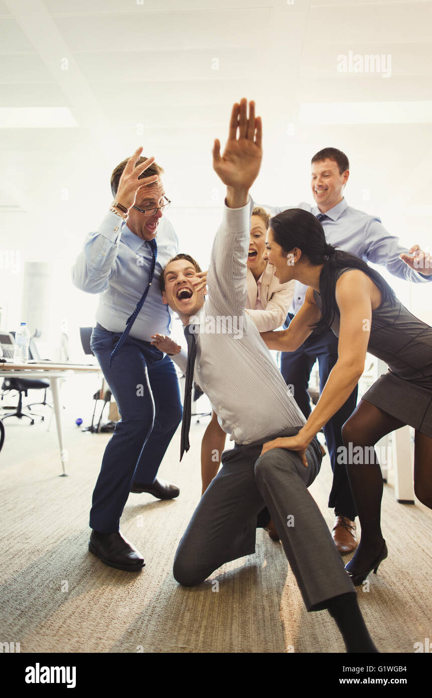 Esuberante la gente di affari che celebra e dancing in office Foto Stock
