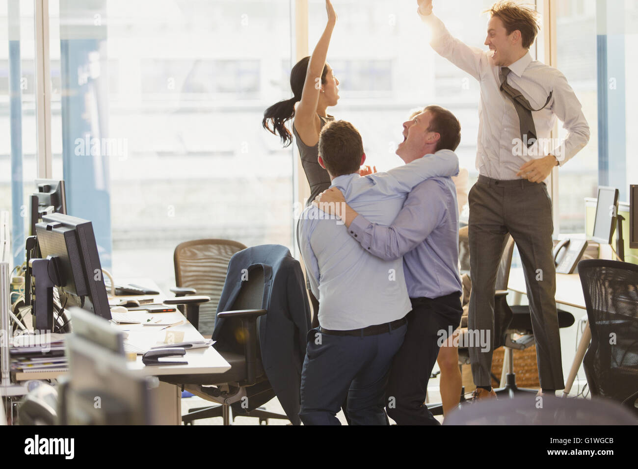 Esuberante la gente di affari che celebra e saltando in office Foto Stock