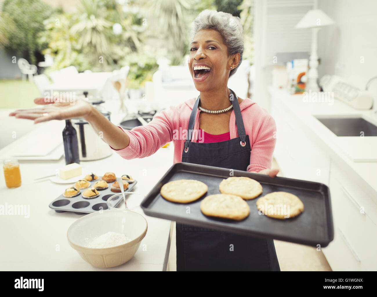 Ritratto entusiastico donna matura i biscotti di cottura e cucina Foto Stock