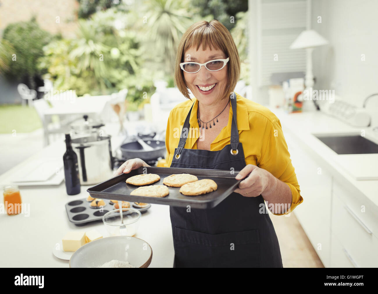 Ritratto sorridente donna matura i biscotti di cottura in cucina Foto Stock