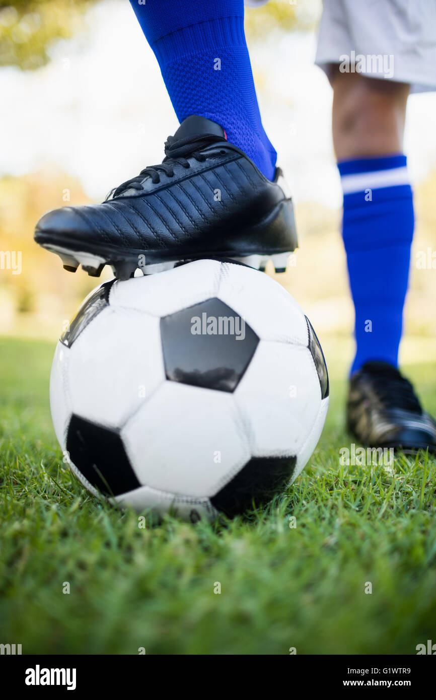 Vista ravvicinata del palloncino sotto gli scarpini da calcio Foto Stock