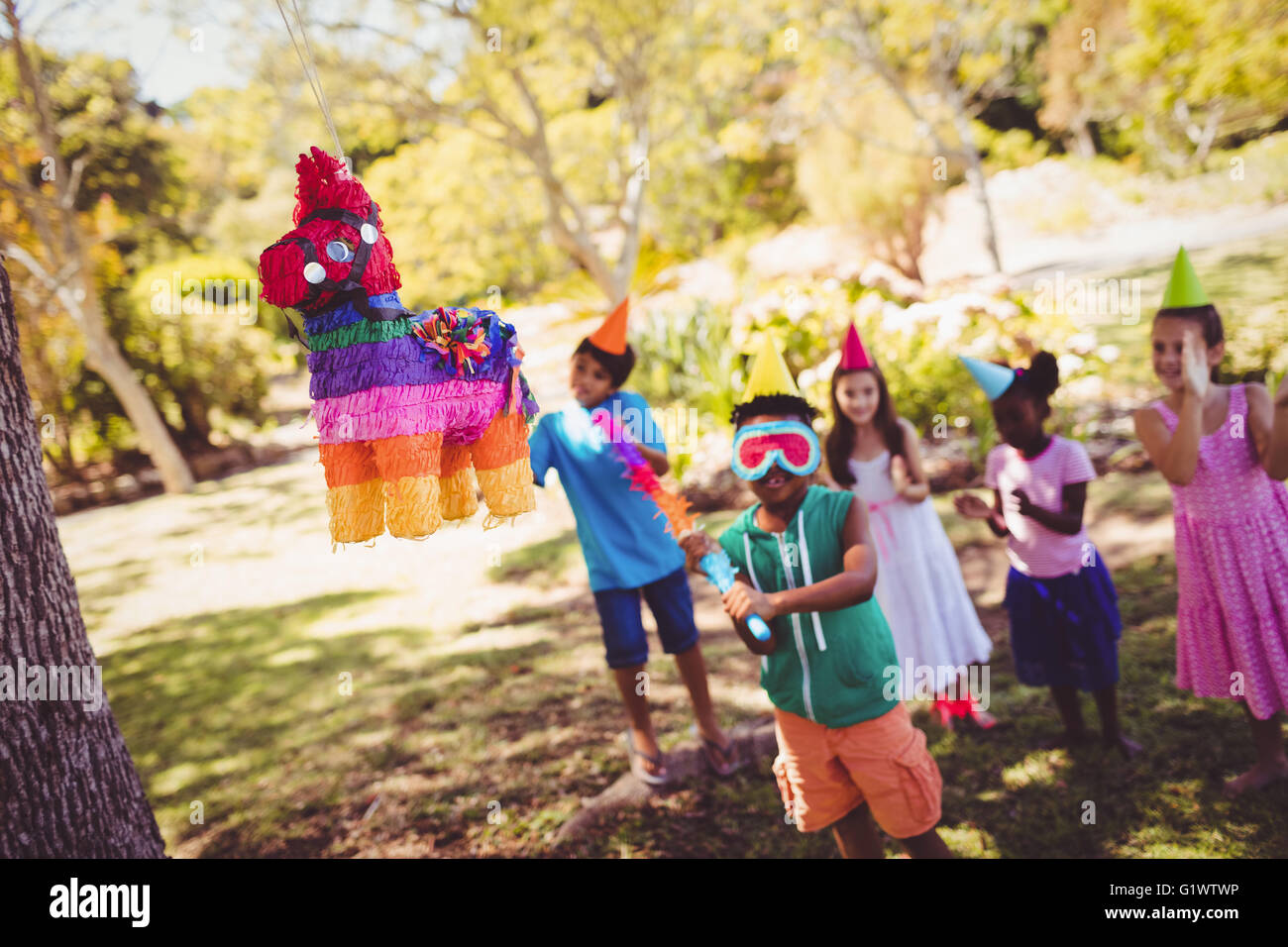 Little Boy sta andando a rotto una pinata per festeggiare il suo compleanno Foto Stock