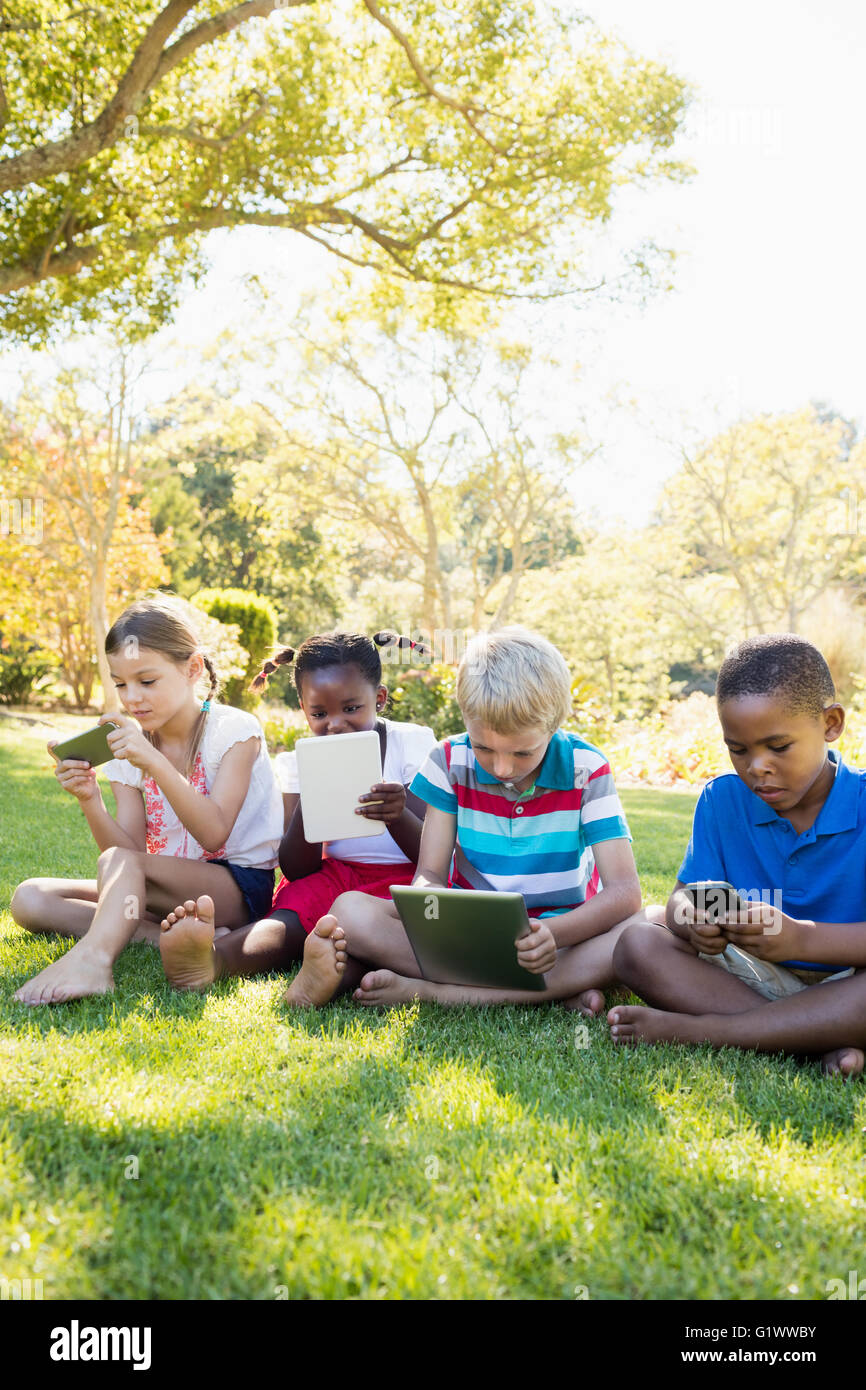 I bambini utilizzando la tecnologia durante una giornata di sole Foto Stock