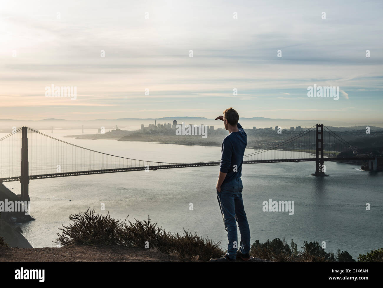 Giovane uomo guarda al Golden Gate Bridge di San Francisco, California, Stati Uniti d'America Foto Stock