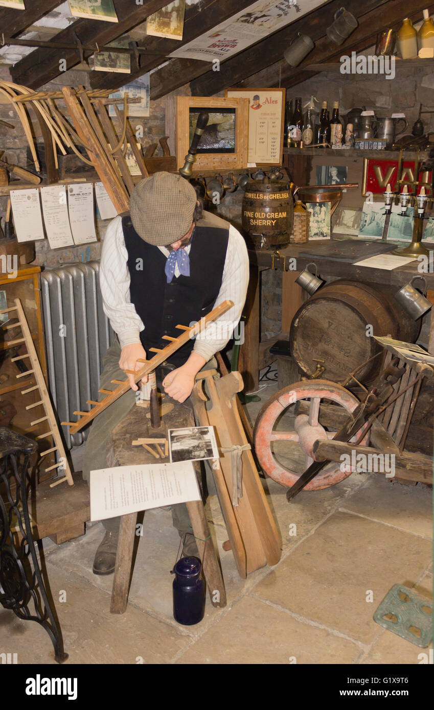 Dent Museo del villaggio e il centro del patrimonio, ammaccature, Yorkshire Dales, Inghilterra. Una dimensione di vita il modello di un uomo che fa un rastrello da fieno. Foto Stock