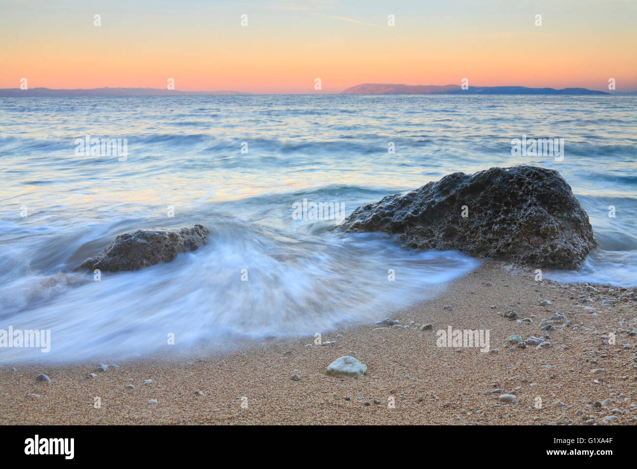 Splash Wave Rock sulla spiaggia sabbiosa di sunrise. Foto Stock