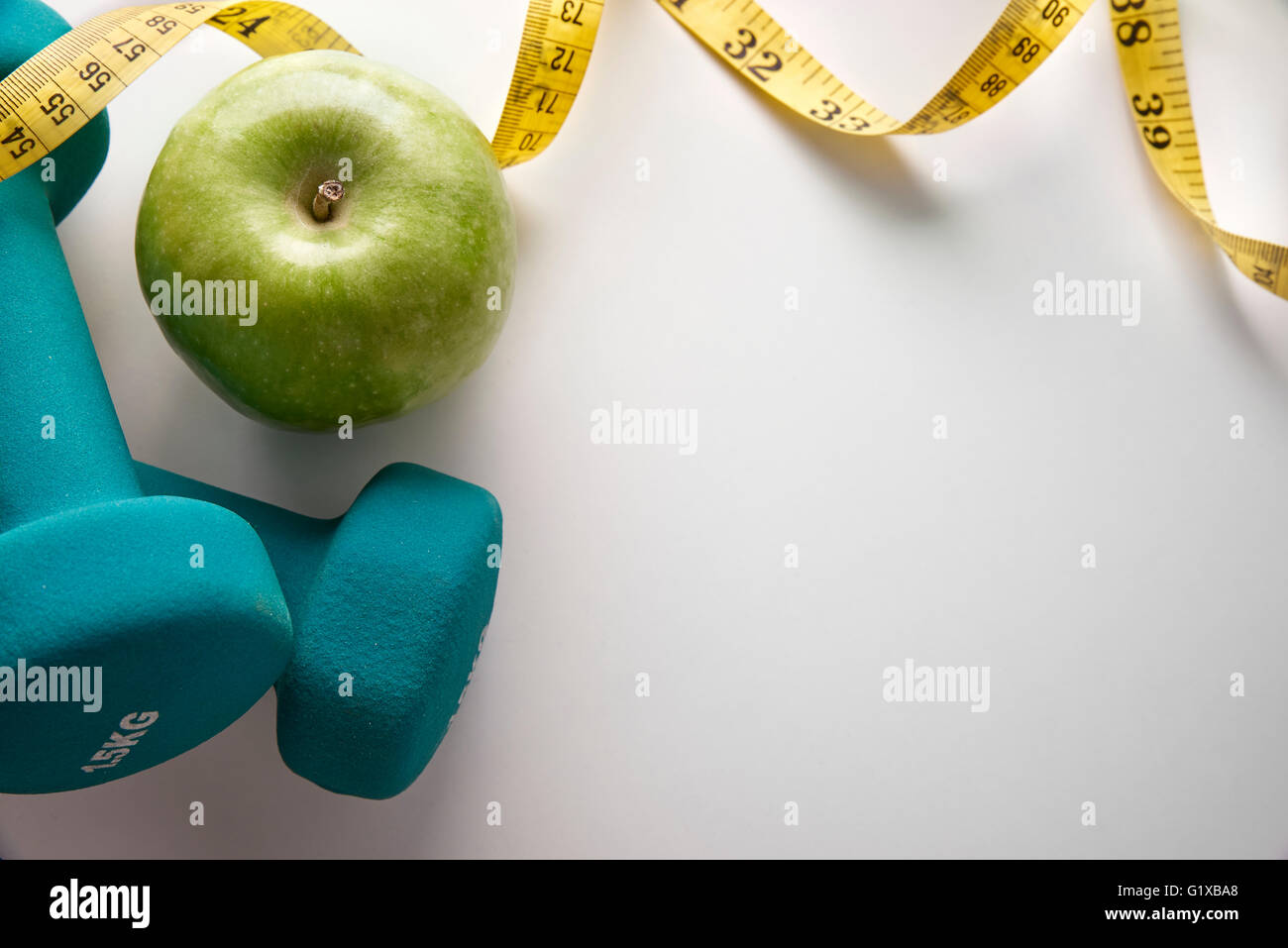 Green manubri con Apple e nastro di misurazione. Concetto la salute, la dieta e sport. Composizione orizzontale. Vista superiore Foto Stock