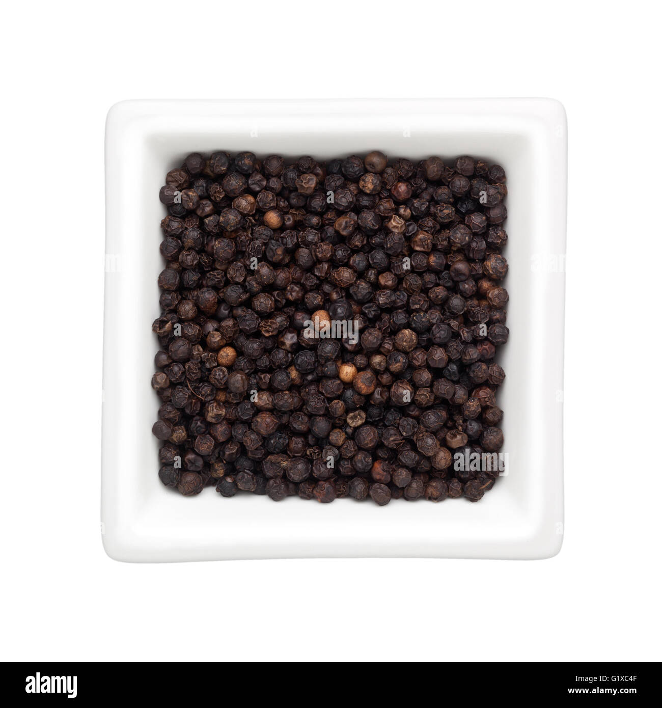 Pepe nero in una ciotola quadrata isolati su sfondo bianco Foto Stock