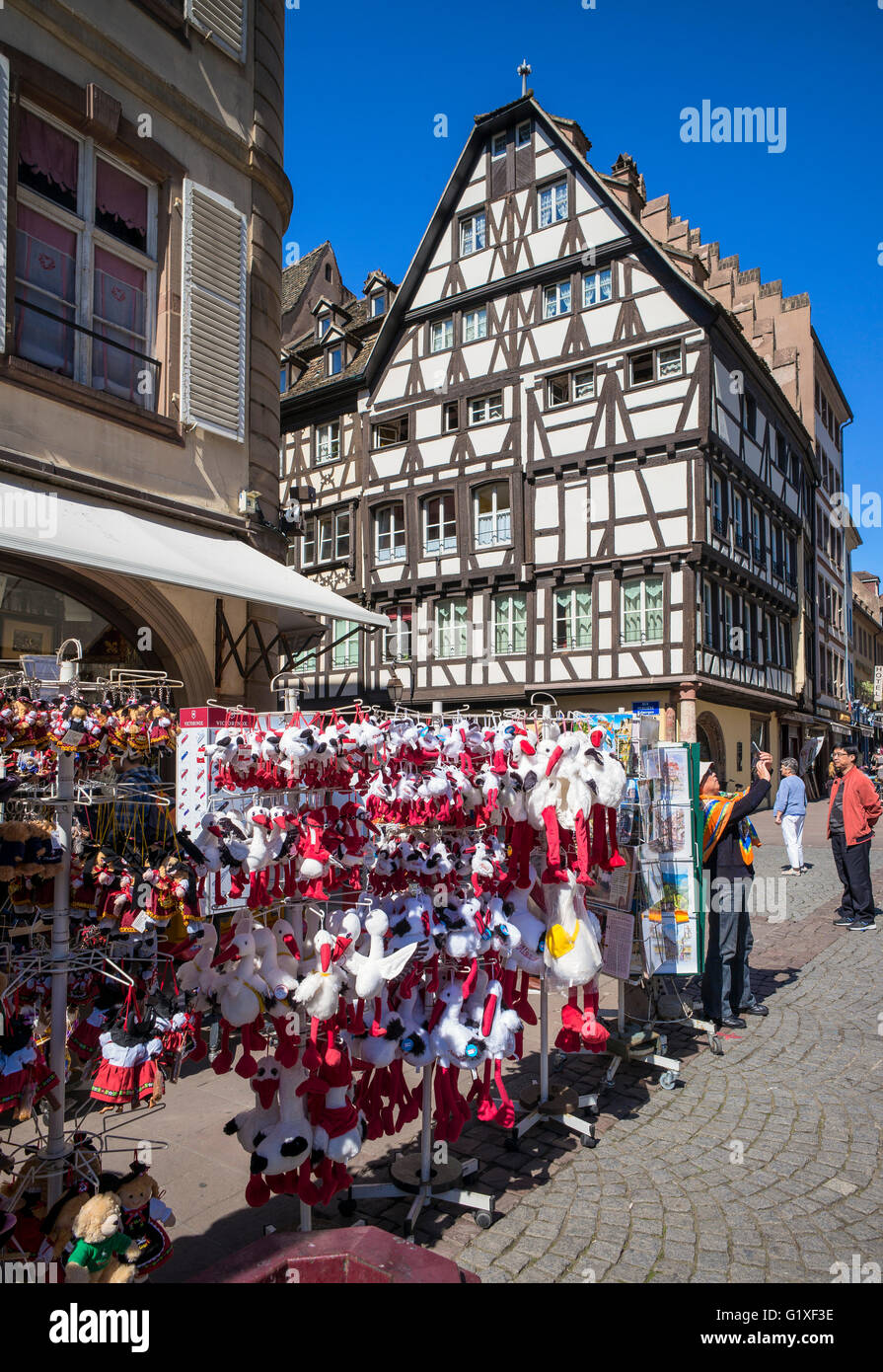 Negozio di souvenir con stork peluche per la vendita e la casa in legno e muratura, Strasburgo, Alsazia, Francia Foto Stock