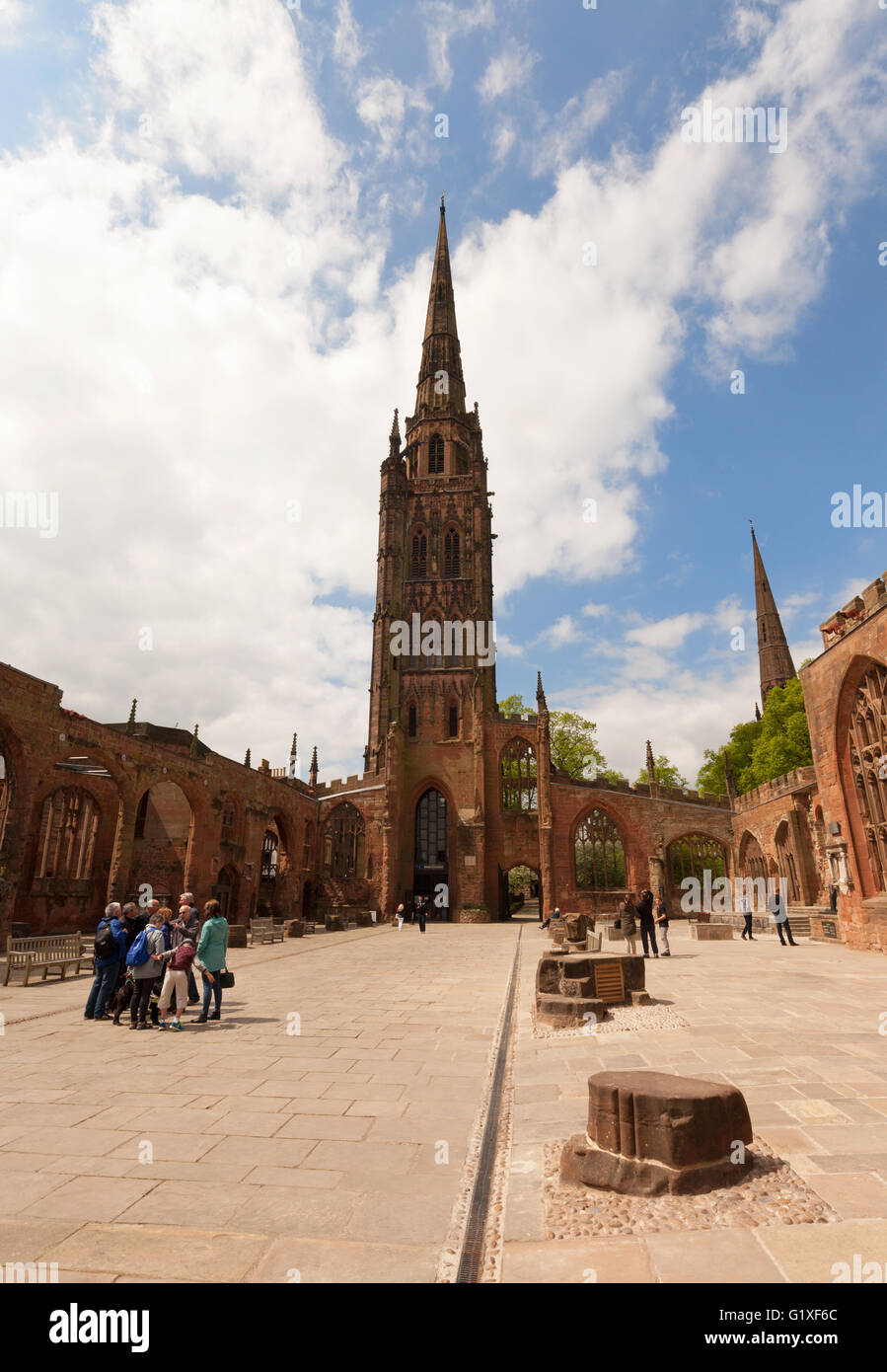 Persone che guardano la guglia in rovina della vecchia St Michael's Cathedral, Coventry; bombardato in WW2; Coventry city centre, Warwickshire, Regno Unito Foto Stock