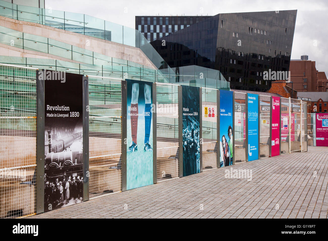 Istruzioni per il cantiere. Building Site advertising hoardings and wire recinto line fuori dal Pier Head Museum, Liverpool Buildings, Merseyside, UK . Foto Stock